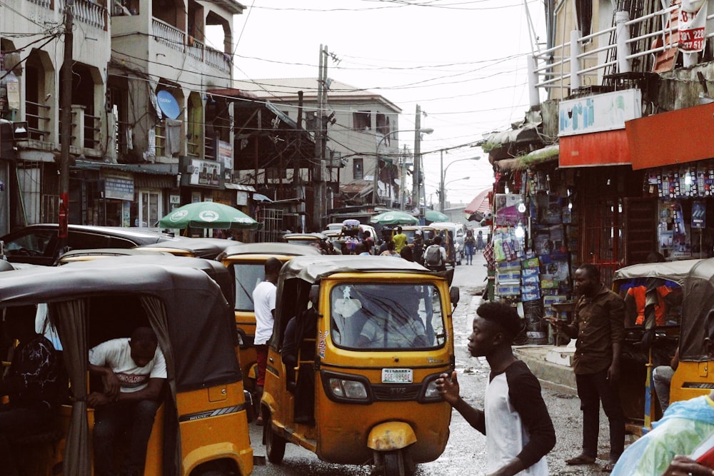 people on street and different vehicles near buildings during daytime