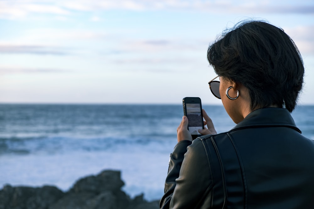 donna in piedi mentre usa il telefono durante il giorno