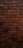 A textured pattern of brown rectangular bricks arranged in a horizontal layout, featuring dark mortar lines between them.