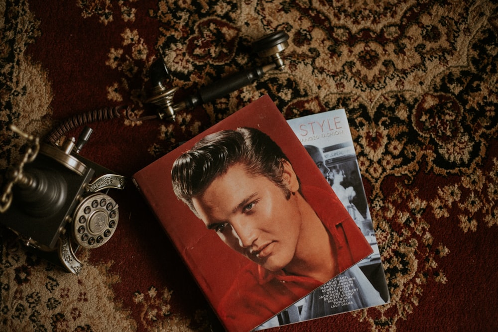 black and gray cradle phone beside Elvis Presley album