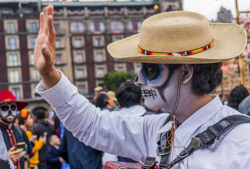 homme portant une chemise blanche avec un masque de peinture de crâne de sucre