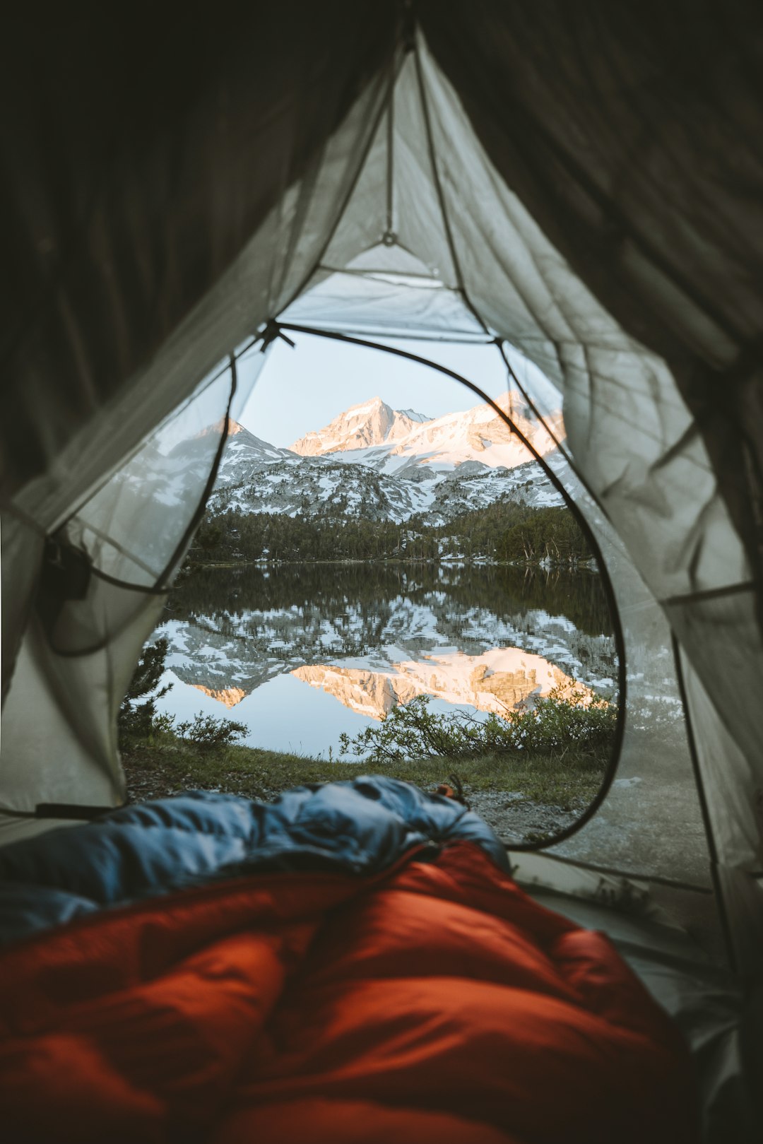 gray and white tent beside lake