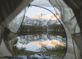 gray and white tent beside lake