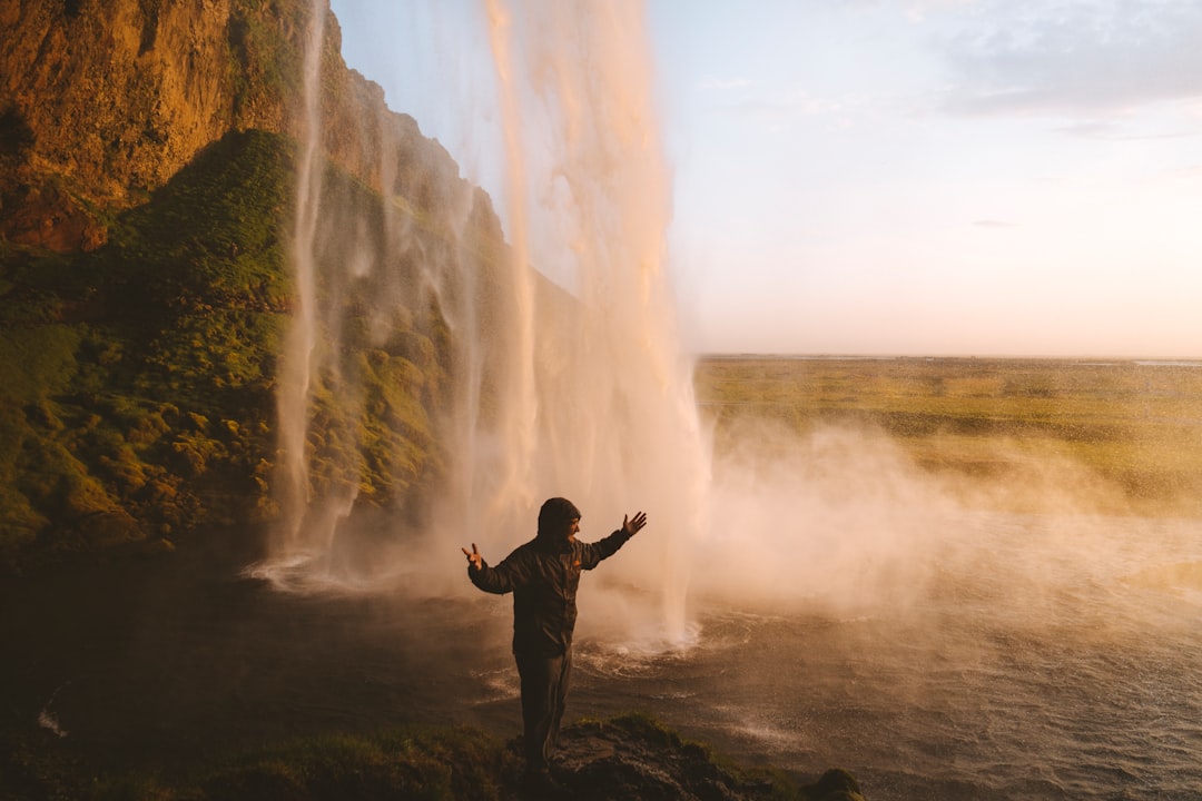 man in a jacket by a waterfall