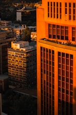 Elegant high-rise luxury apartment with city skyline at dusk, bathed in warm golden light.