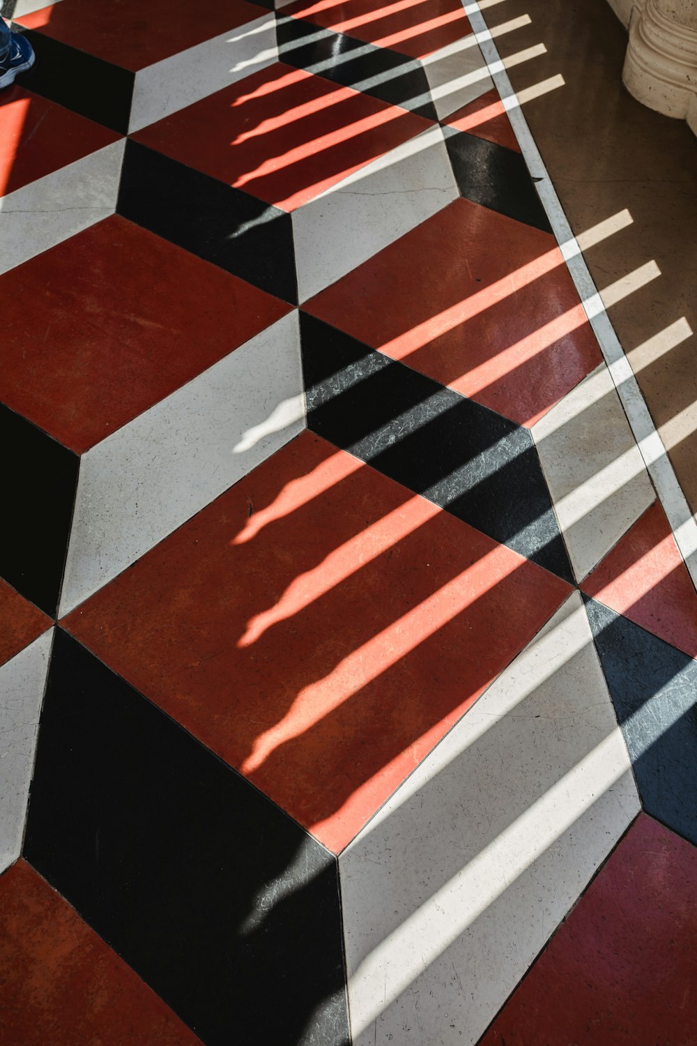 a red and white checkered floor with long shadows