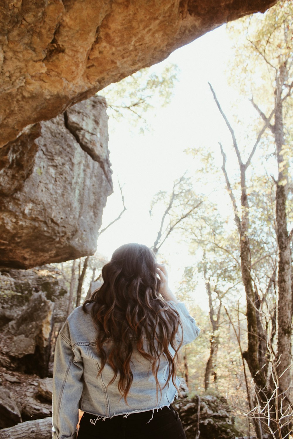 woman wearing blue denim jacket inside cave