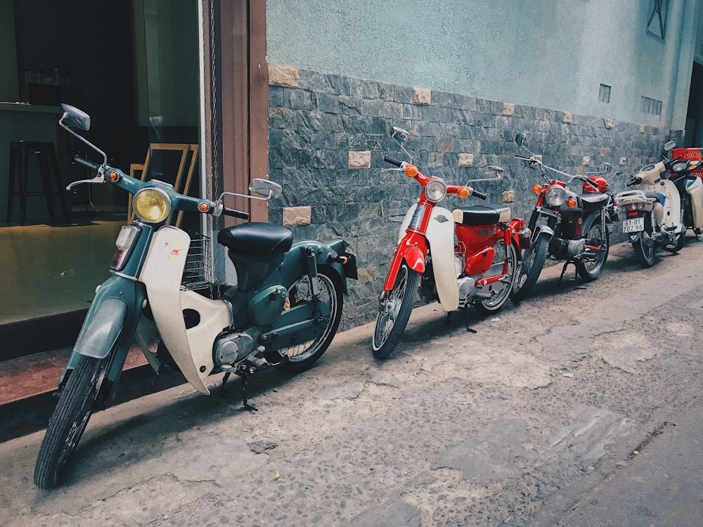 four parked assorted-color motorcycles