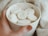 A smiling customer enjoying a cup of hot chocolate from Cozys.