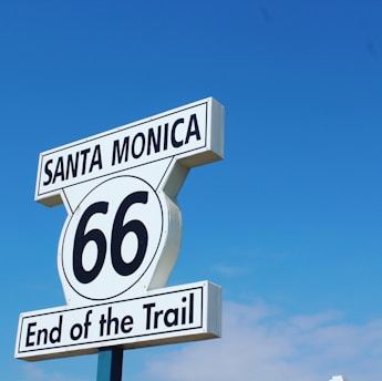 A signpost against a clear blue sky displaying 'Santa Monica 66 End of the Trail'.