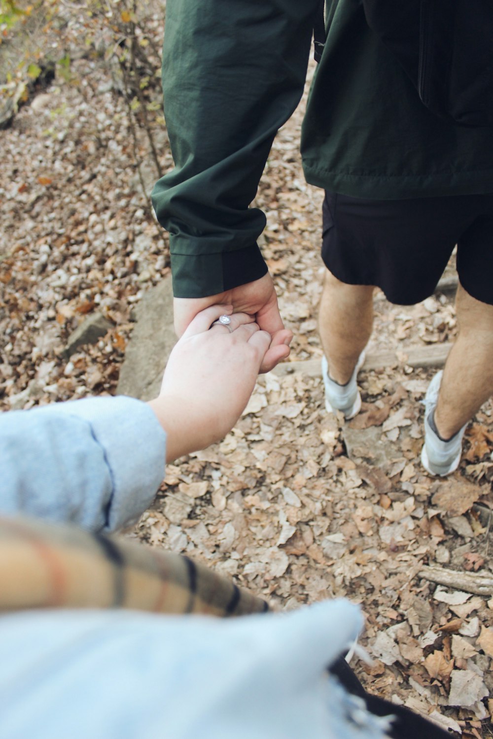 two person holding hands while walking on stair