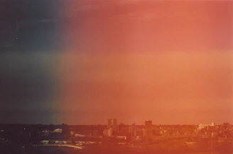 Hand-drawn continuous line art of the Rochester skyline with subtle purple-to-orange gradient accents.