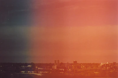 Hand-drawn continuous line art of the Rochester skyline glowing in purple-to-orange gradient.