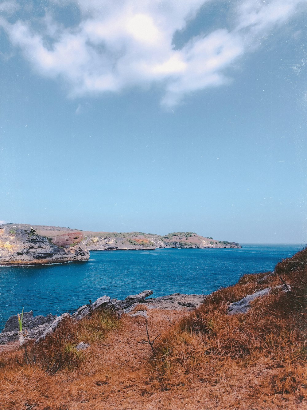 blue body of water under white clouds and blue sky