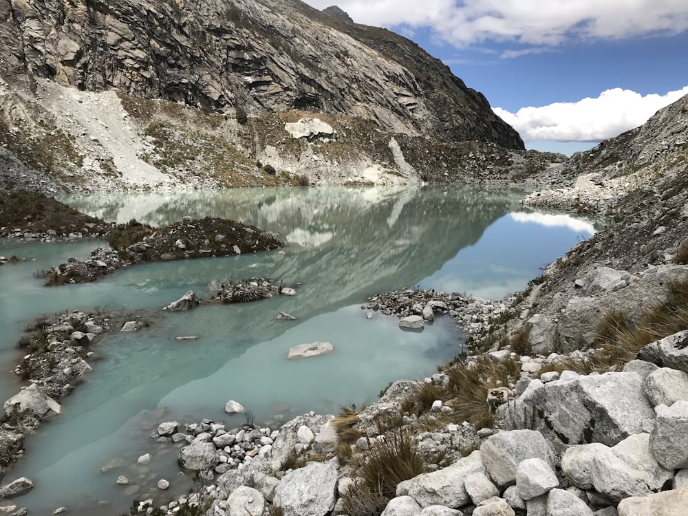 blue body of water surrounded by mountains