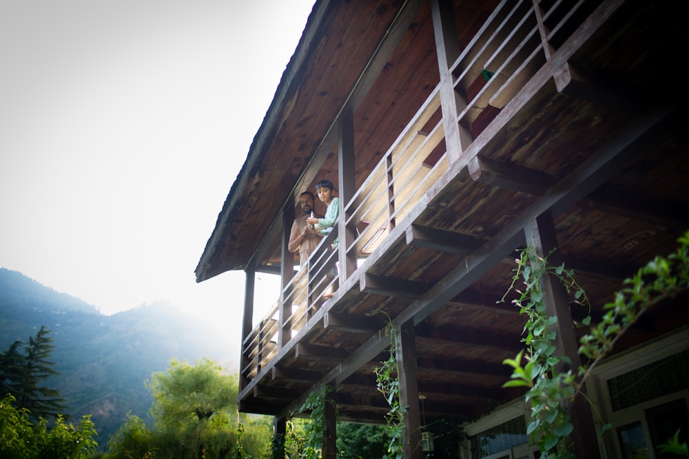 low-angle photography of man and boy standing in front of house fence