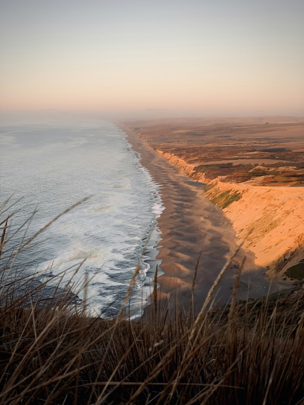 aerial photography of waves splashing on seashore during daytime