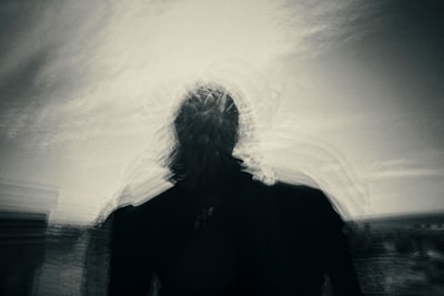 silhouette of person under gray sky intense zoom background