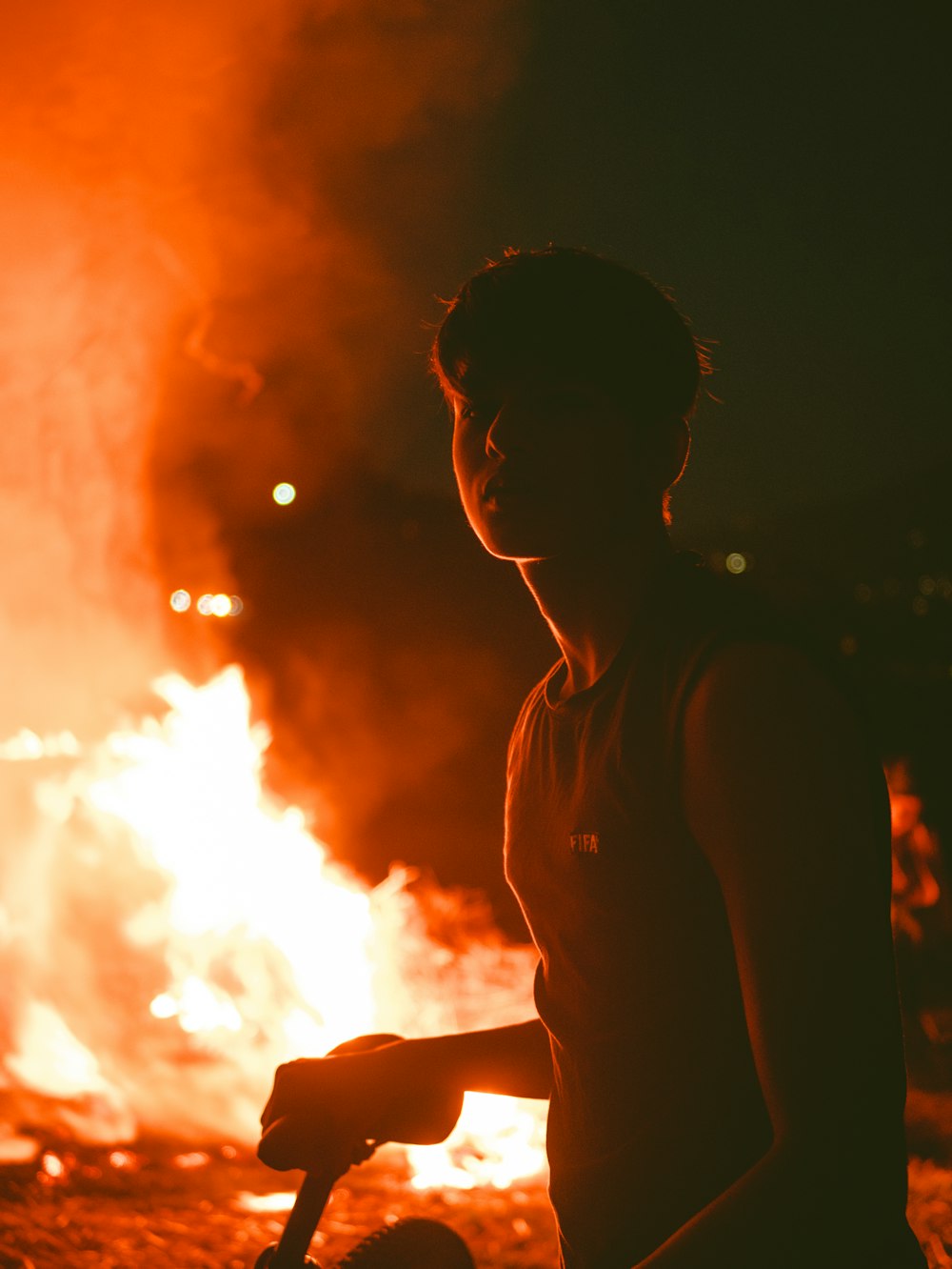 man standing beside bike near fire