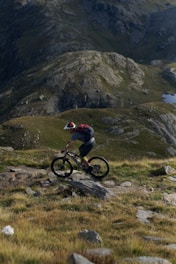 A biker girl riding through a scenic mountain landscape.