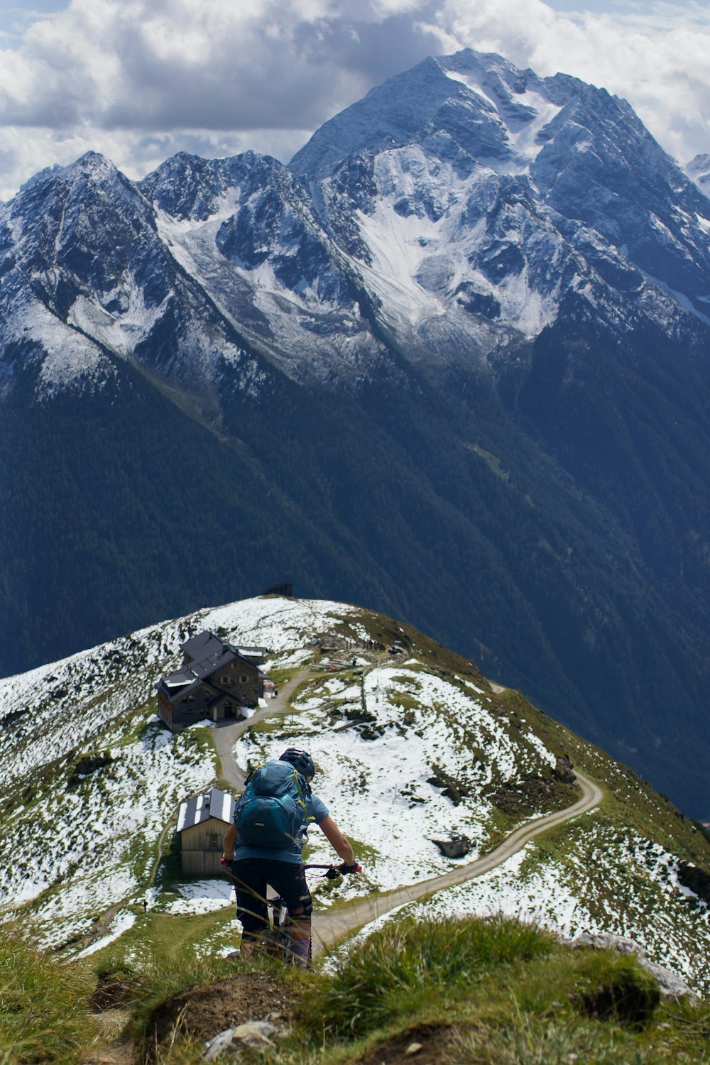 person cycling on green mountain during daytime