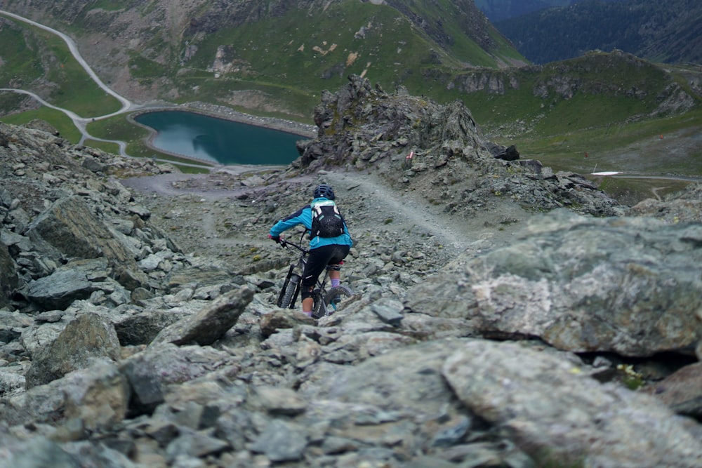 man riding on bicycle towards body of water