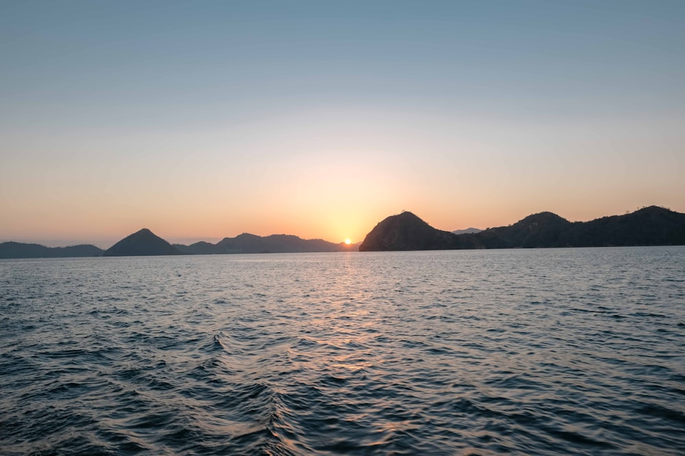 ocean near mountain during sunrise