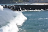 A coastal breakwater with waves crashing against it.
