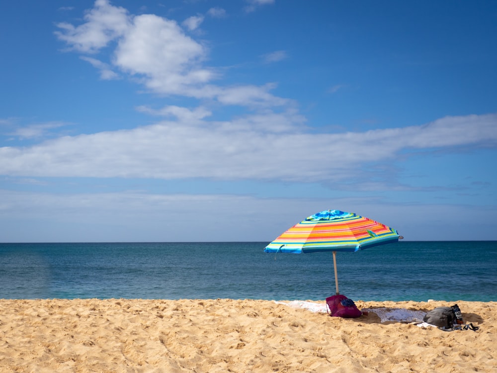 orange and blue beach umbrella on seashore