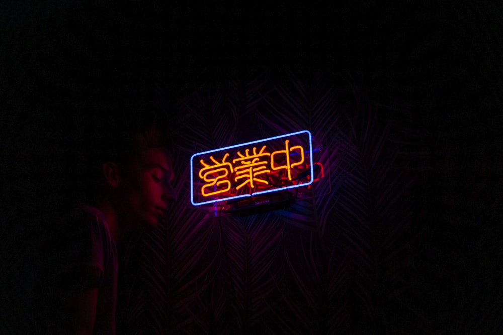 man near orange kanji LED lights