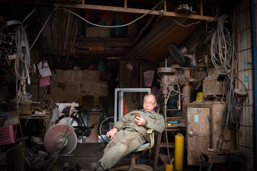 A professional craftsman checking service requests on a tablet in a workshop.