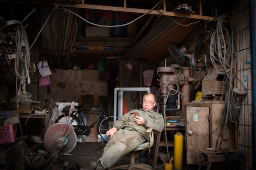 A friendly handyman answering a phone call in a cozy workshop.