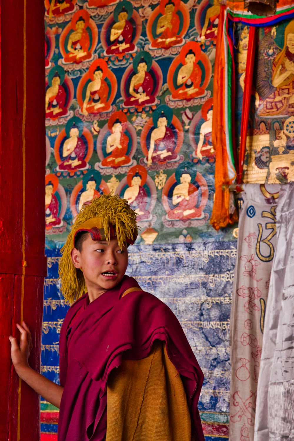 uomo che indossa il vestito tradizionale del monaco rosso e giallo