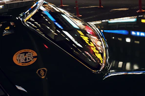 Night view of a Yakuplu Korsan Taksi car with city lights reflecting on its surface