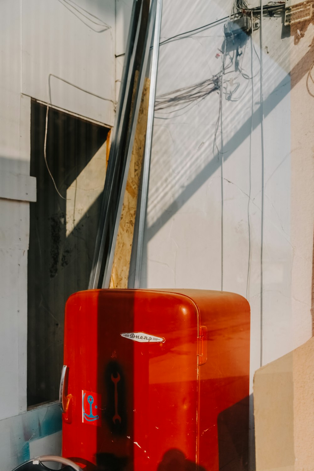 a red piece of luggage sitting in front of a building