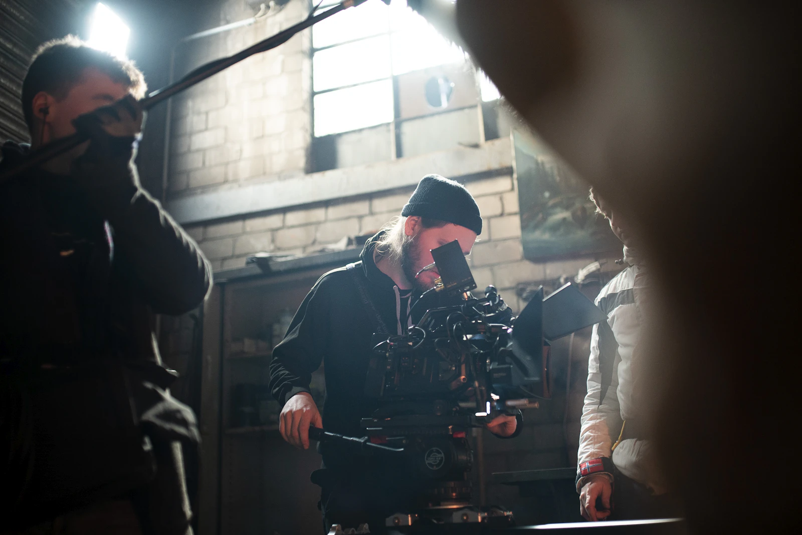 Cinematographer in a beanie guiding a camera on set