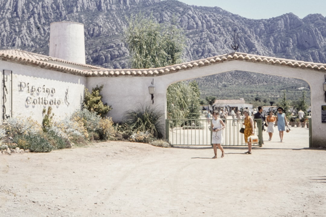 people walking on brown sand near white concrete building during daytime