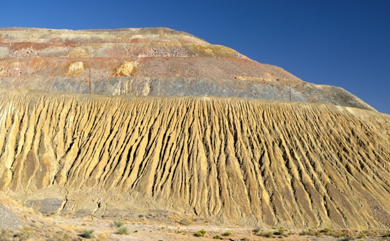 A detailed geological cross-section illustrating rock layers and fault lines under a clear sky.