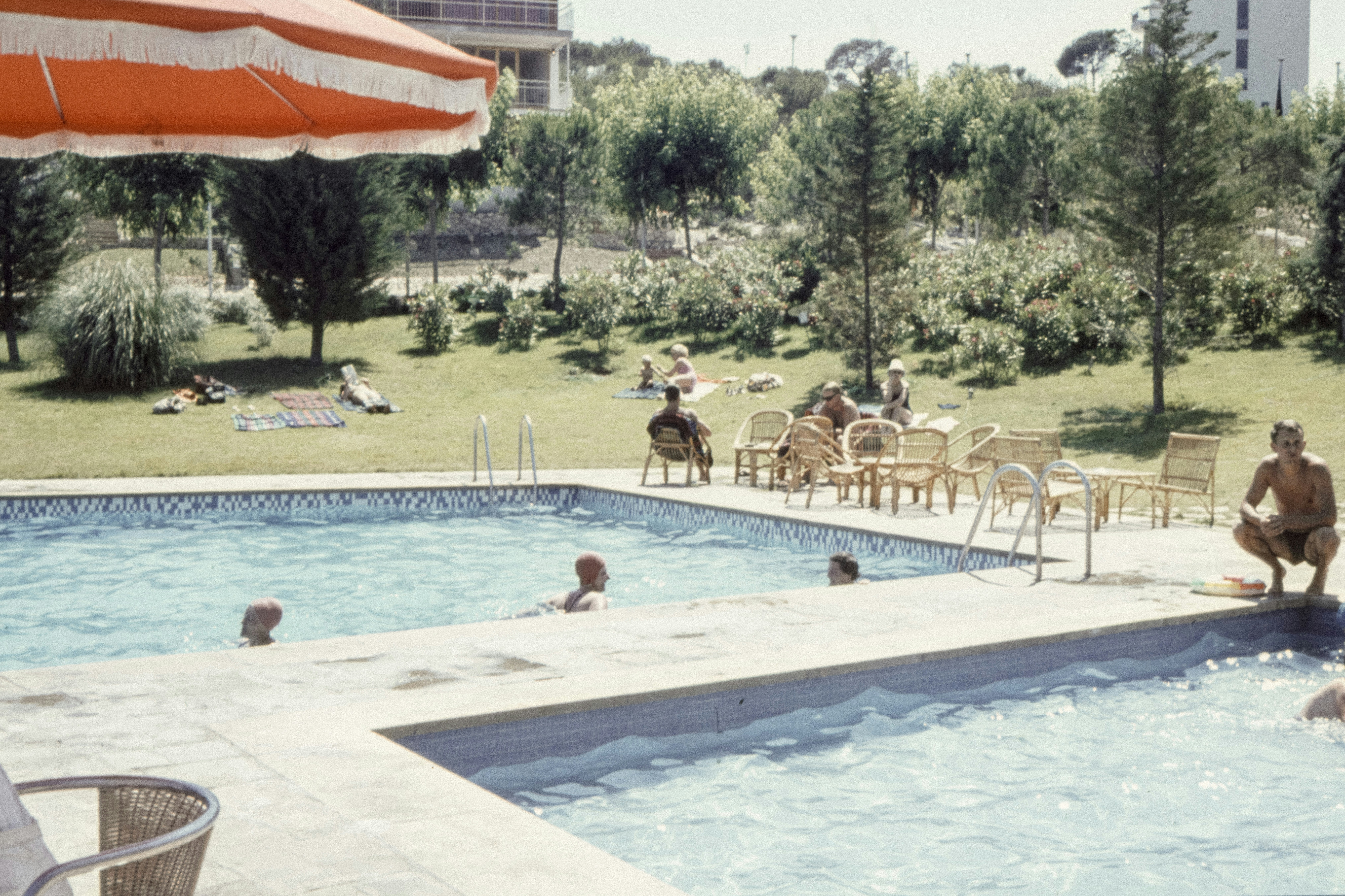 man wearing black brief sitting beside on pool