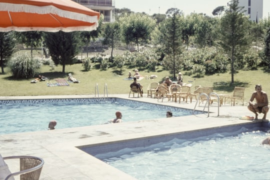 man wearing black brief sitting beside on pool in Collbató Spain