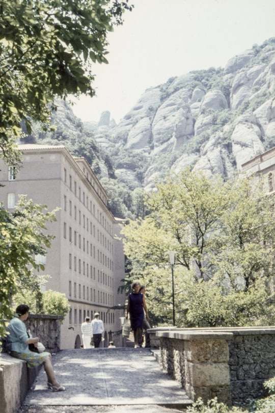 woman wearing purple dress walking on street in Collbató Spain