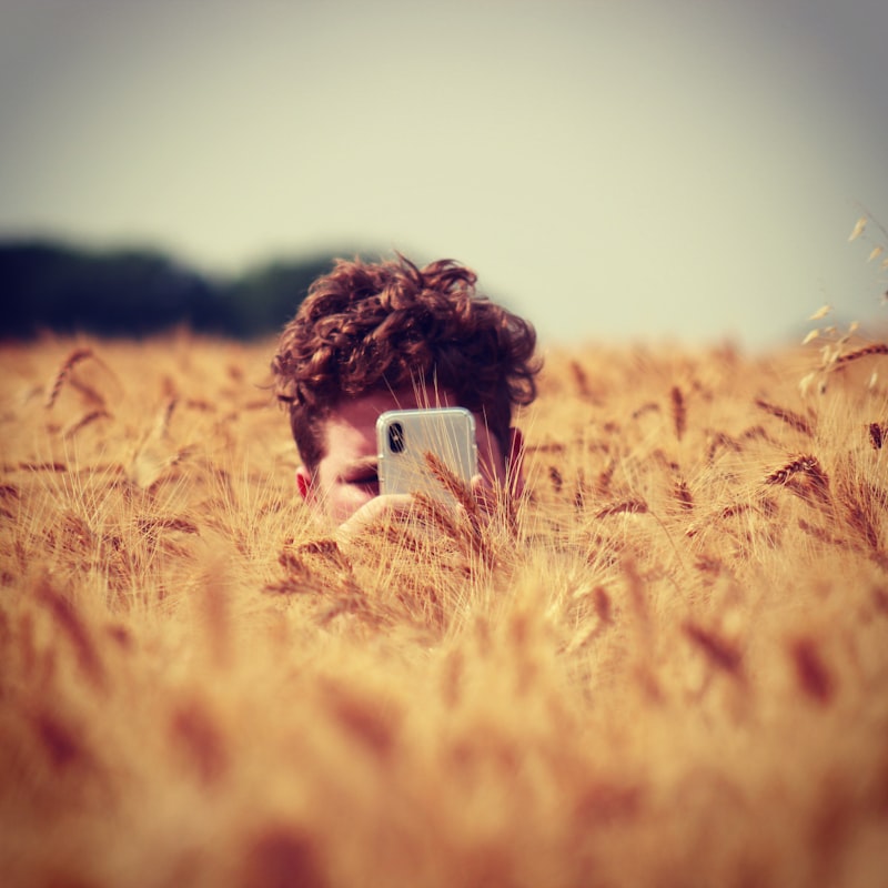 Farmer holding up his phone in a wheat field