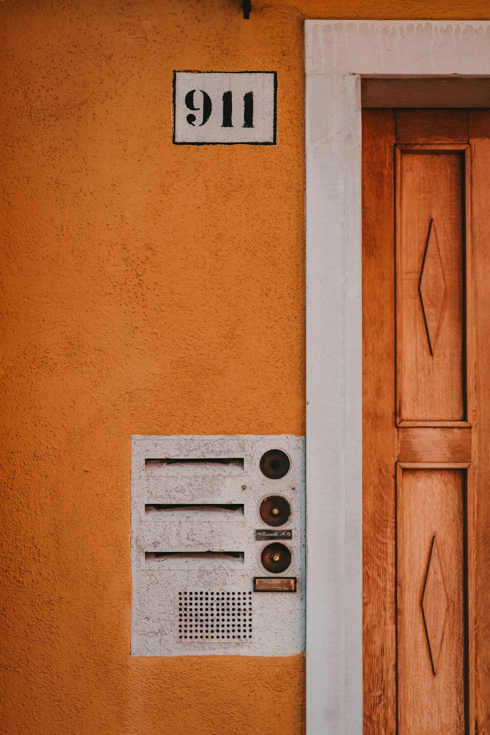 911 signage beside brown wooden door