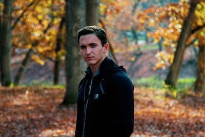 Outdoor shot of a model wearing a shell jacket embraced by crisp autumn leaves.