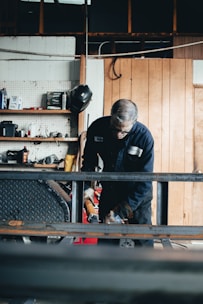 An instructor demonstrating the use of personal protective equipment in a workshop setting.