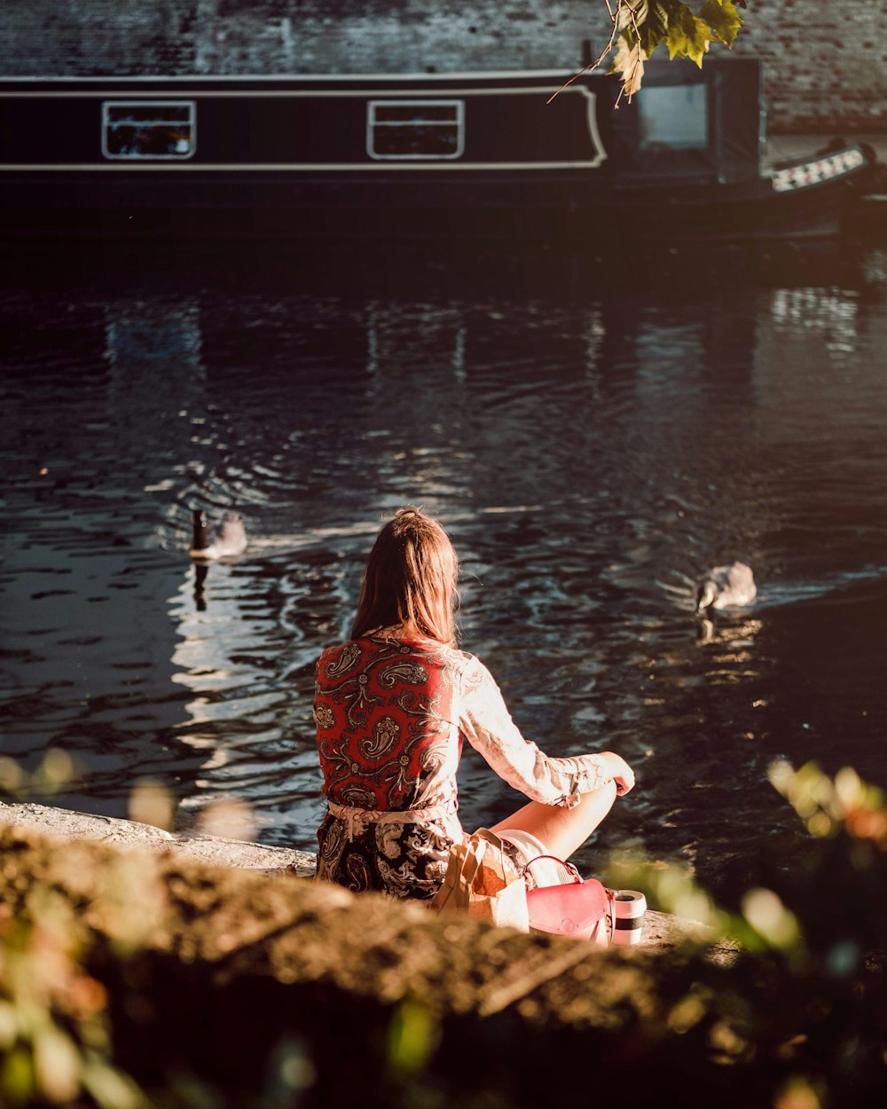 池の近くに座っている女性