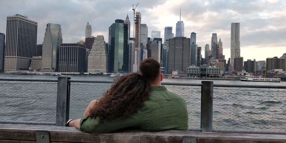 couple sitting on a bench fronting a cityscape