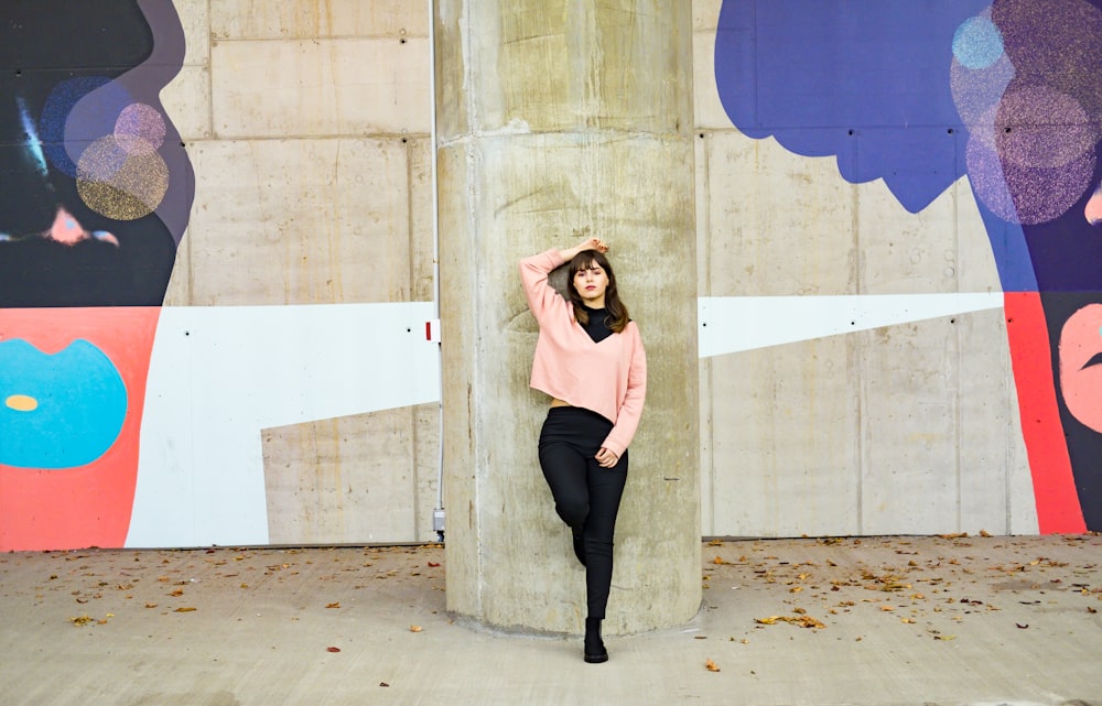 woman wearing pink long-sleeved shirt and black pants