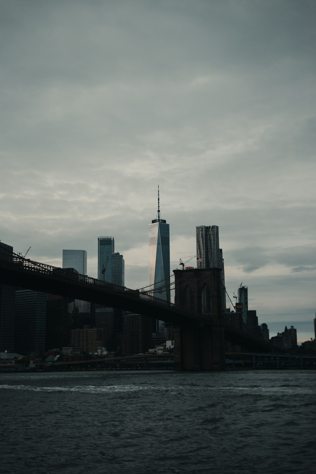 cityscape facing body of water under gray sky