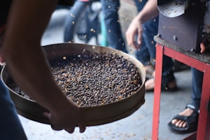 a person holding a pan of food on a table